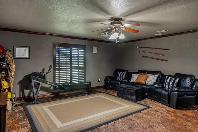 a living room with furniture gym equipment and a flat screen tv
