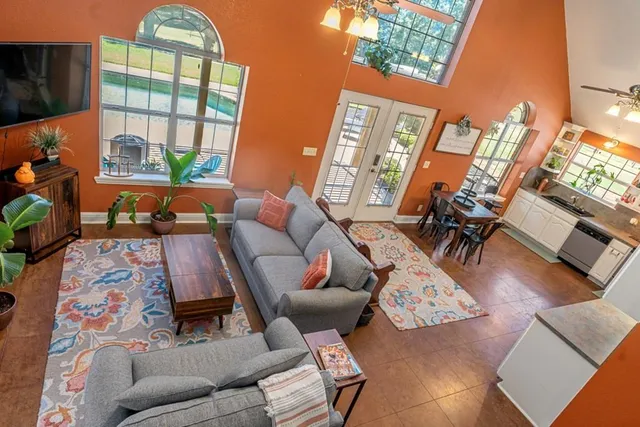 a living room with furniture a fireplace and a floor to ceiling window