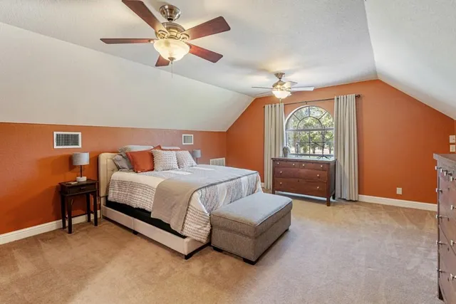 a spacious bedroom with a bed and a chandelier