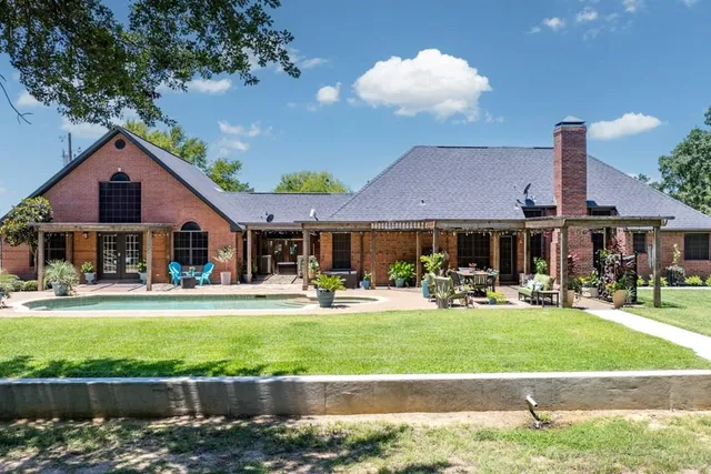 a front view of a house with swimming pool having outdoor seating