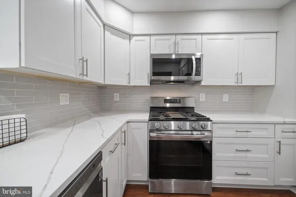 a kitchen with white cabinets and stainless steel appliances
