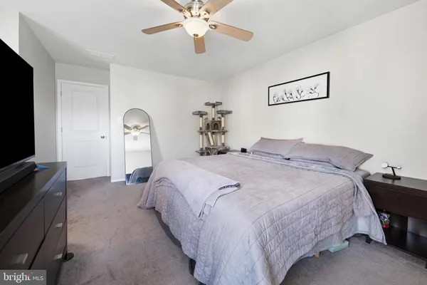 a bedroom with bed and a flat tv screen on dresser