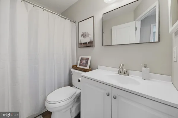 a bathroom with a sink vanity mirror and toilet