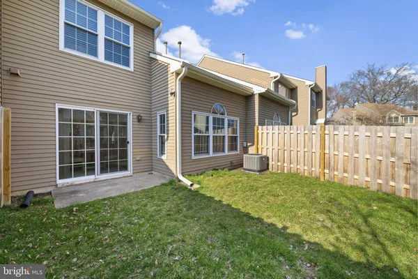 a view of a house with a yard and wooden fence