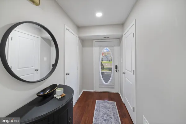 an entryway with wooden floor and mirror
