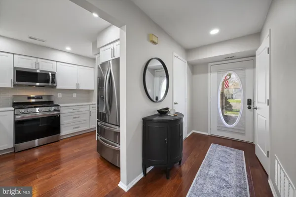a kitchen with granite countertop a refrigerator stove and microwave