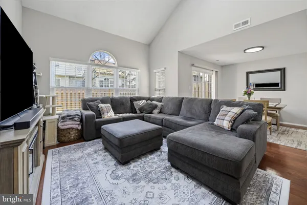 a living room with furniture a flat screen tv and a window