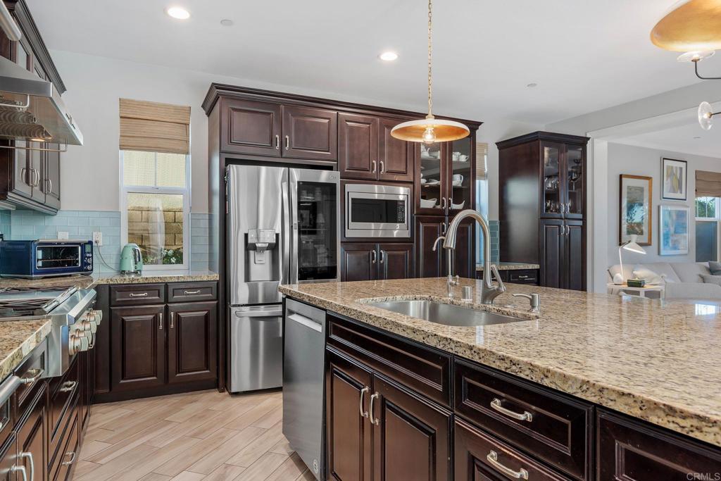 13525 Cielo Ranch Road San Diego, CA 92130 - Photo 14 of 49 a kitchen with stainless steel appliances granite countertop a sink and dishwasher a refrigerator with wooden cabinets