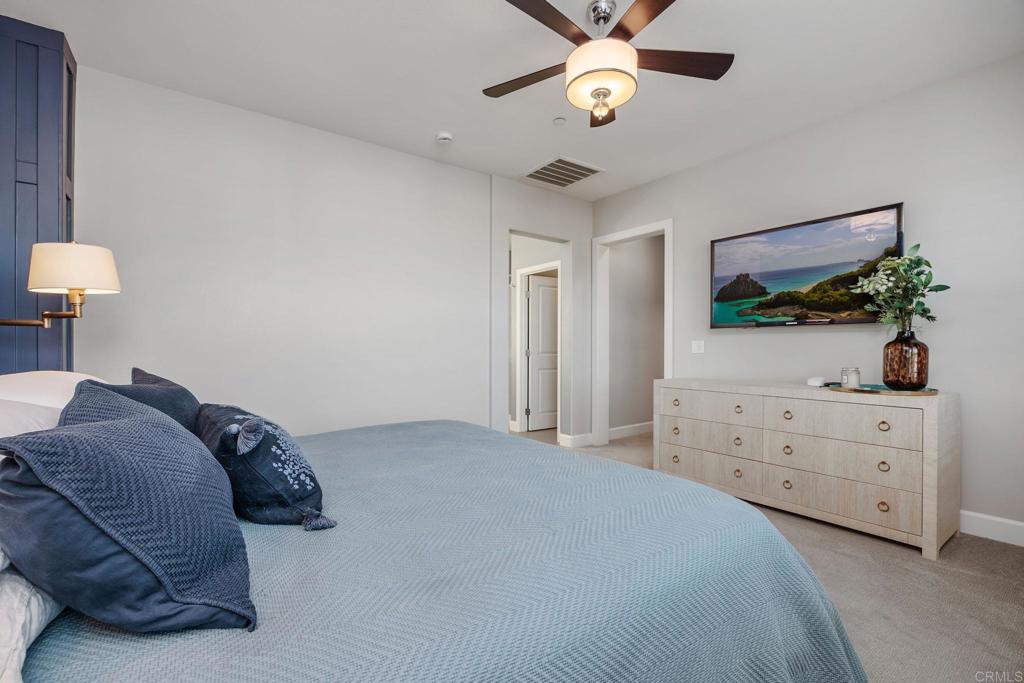 13525 Cielo Ranch Road San Diego, CA 92130 - Photo 21 of 49 a bedroom with a bed chandelier and a dresser