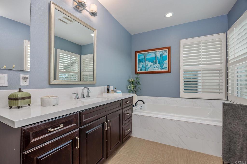 13525 Cielo Ranch Road San Diego, CA 92130 - Photo 22 of 49 a bathroom with a tub double sink window and mirror