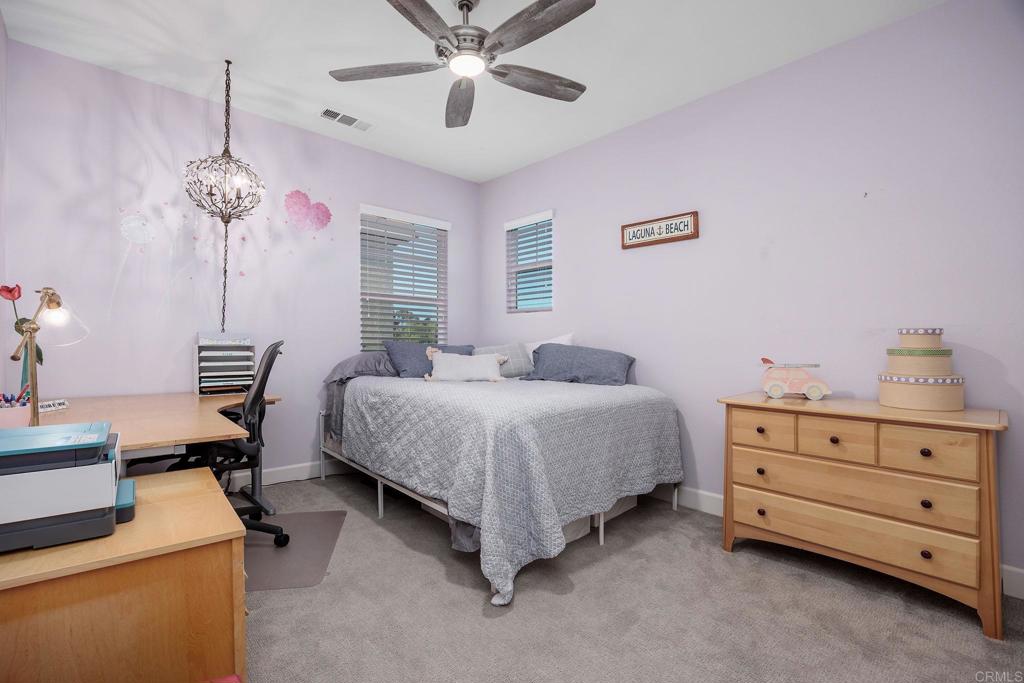 13525 Cielo Ranch Road San Diego, CA 92130 - Photo 24 of 49 a bedroom with a bed and a chandelier