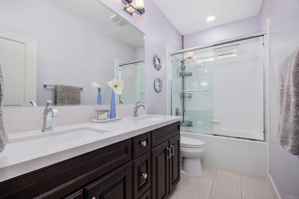 13525 Cielo Ranch Road San Diego, CA 92130 - Photo 25 of 49 a bathroom with a double vanity sink toilet mirror and shower