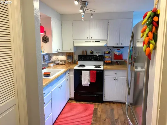 a kitchen with stainless steel appliances granite countertop a sink and a refrigerator