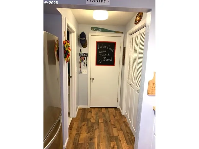 a view of a hallway with wooden floor and staircase