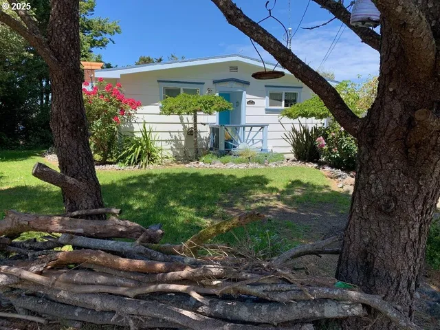 a view of a house with a yard and a tree