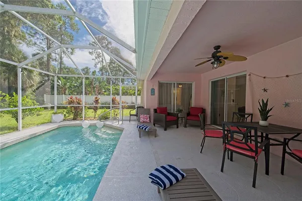 a view of a backyard with couches plants and large trees