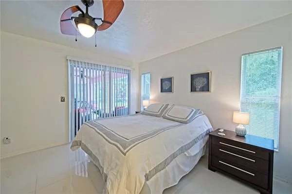 a bedroom with a bed chandelier and a window