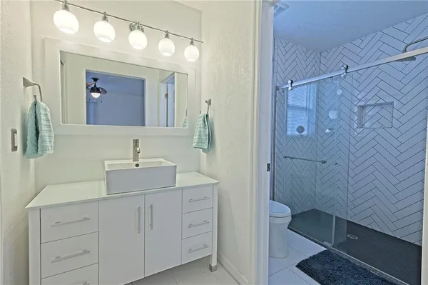 a bathroom with a double vanity sink mirror and shower