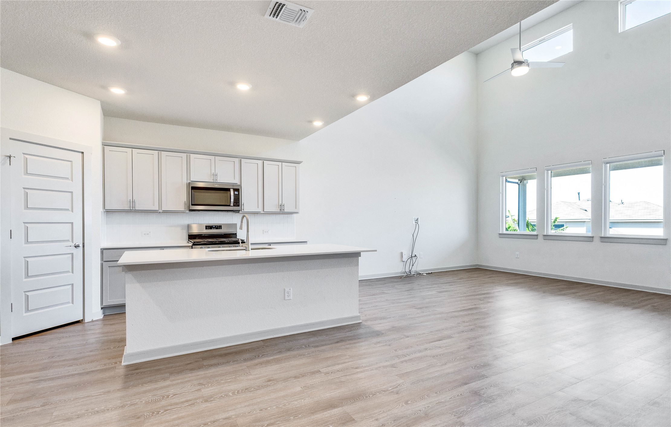 10508 Defender Trail Austin, TX 78754 - Photo 12 of 28 A contemporary open-concept space features vaulted ceilings, ample natural light, and a stylish kitchen island with integrated sink.