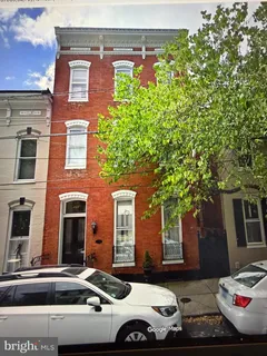 a front view of a house with cars parked