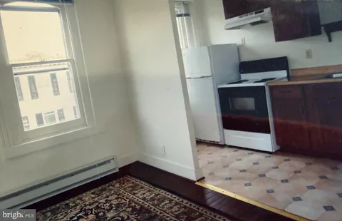 a view of a bedroom with wooden floor and a window