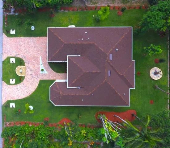 an aerial view of a house with backyard space and pool