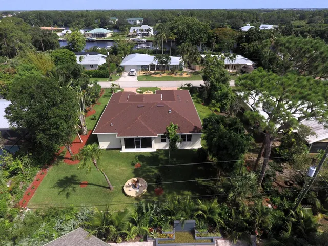 an aerial view of residential houses with outdoor space and trees