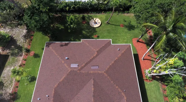 a aerial view of a house with garden space and a lake view in back