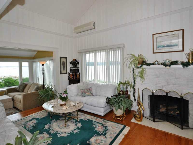 16 East Shore Road Jamestown, RI 02835 - Photo 7 of 20 Living Room. The living room has a wood burning fireplace and opens to a room full of windows overlooking the beach.