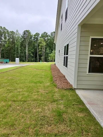 a view of a backyard with a garden and entertaining space