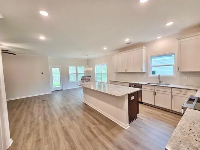 a large kitchen with stainless steel appliances granite countertop a stove and a wooden floors