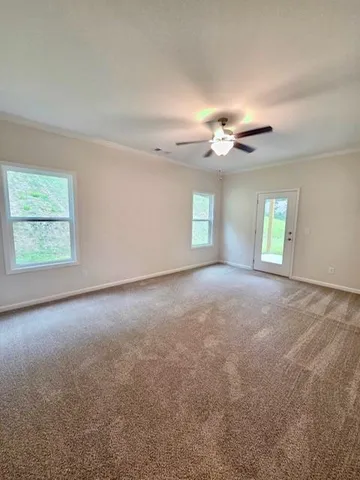 an empty room with windows and ceiling fan