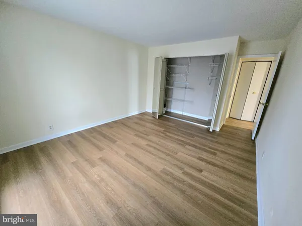 a view of an empty room with closet and a window
