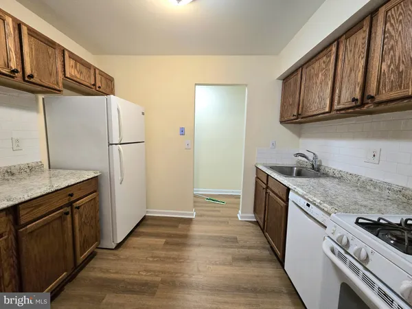 a kitchen with stainless steel appliances granite countertop a refrigerator a stove and a sink
