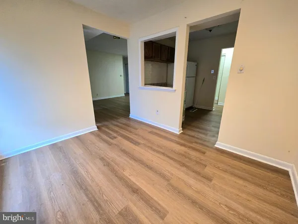 an empty room with wooden floor and entrance