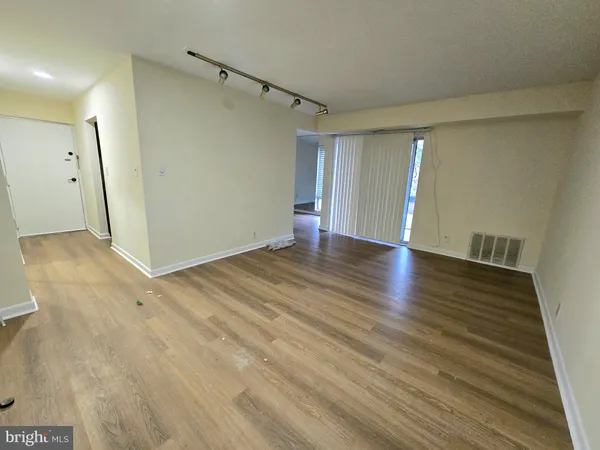 a view of an empty room with wooden floor