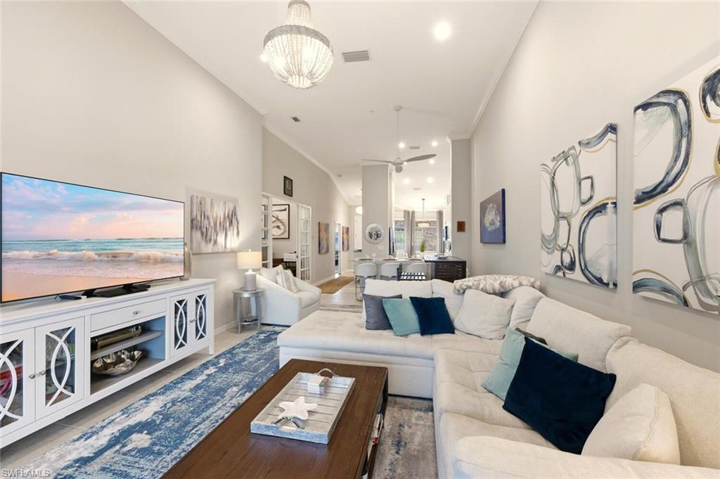 9365 Pocida Court, Unit 202 Naples, FL 34119 - Photo 15 of 40 a living room with fireplace furniture and a flat screen tv