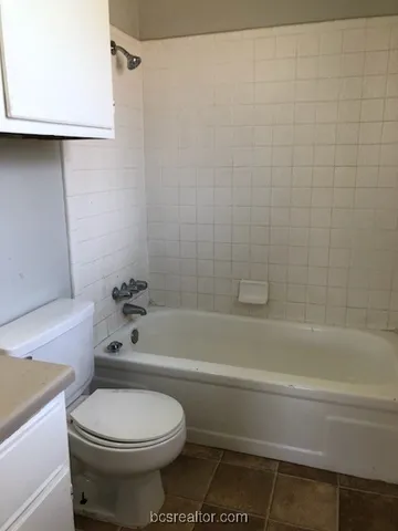 a bathroom with a toilet and a bathtub