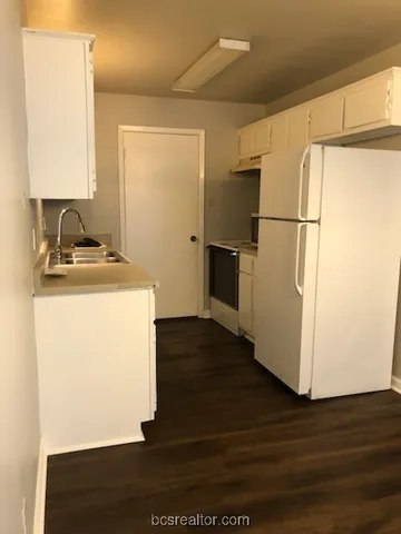 a utility room with wooden floor washer and dryer