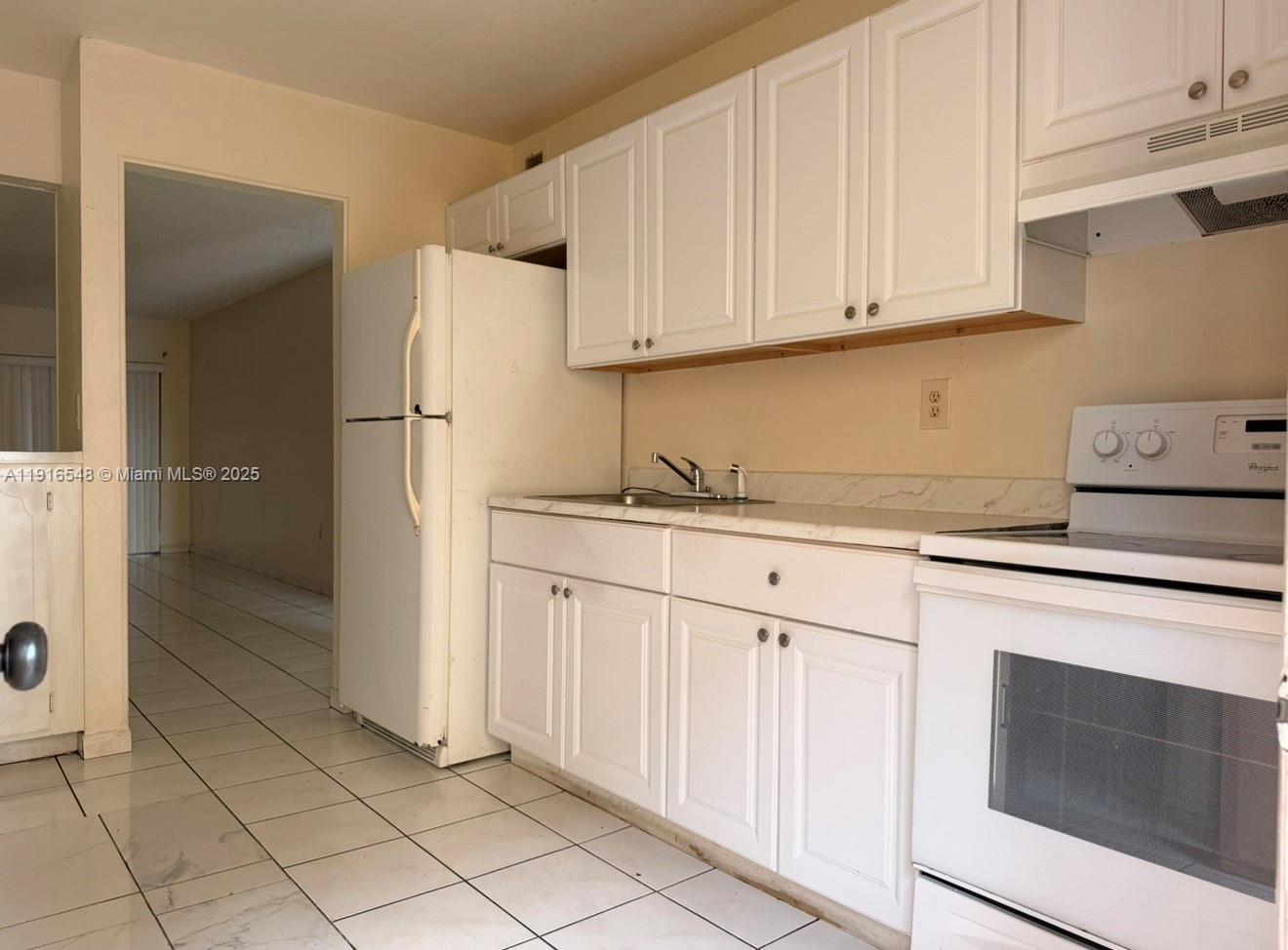 1900 West 54th Street, Unit 320 Hialeah, FL 33012 - Photo 7 of 19 a kitchen with granite countertop white cabinets and stainless steel appliances