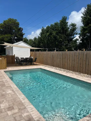 a view of backyard with wooden fence
