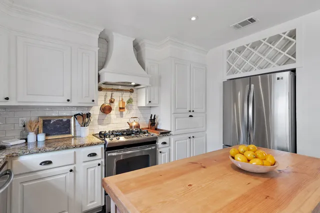 a kitchen with stainless steel appliances a stove a sink cabinets and a refrigerator