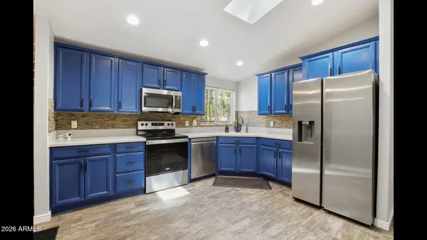 a kitchen with granite countertop wooden cabinets and stainless steel appliances