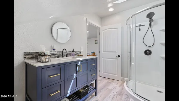 a bathroom with a granite countertop sink mirror and a shower