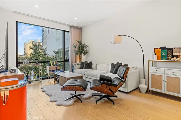 a living room with furniture a rug and white walls