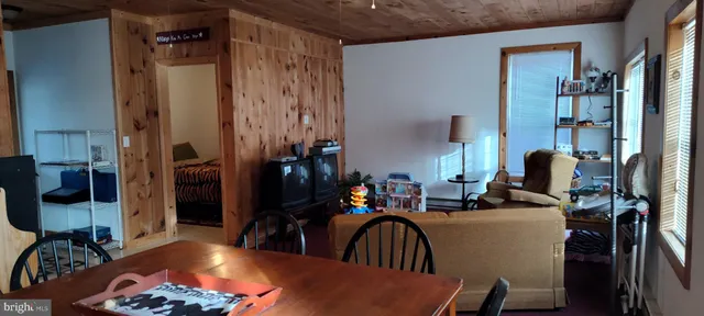 a living room with furniture a bookshelf and a window