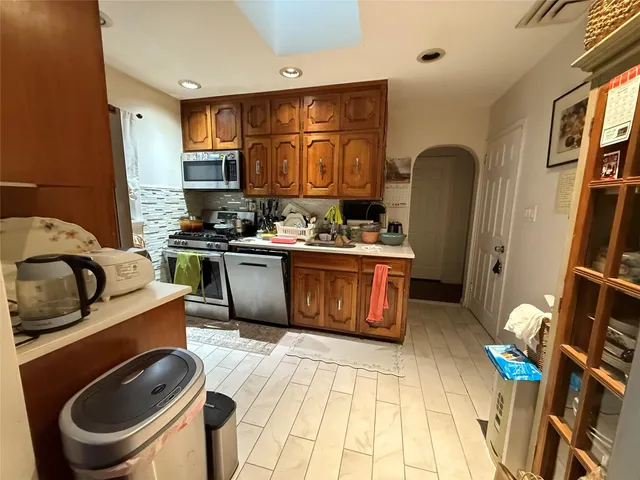 a kitchen with stainless steel appliances granite countertop a sink a stove a refrigerator cabinets and chairs