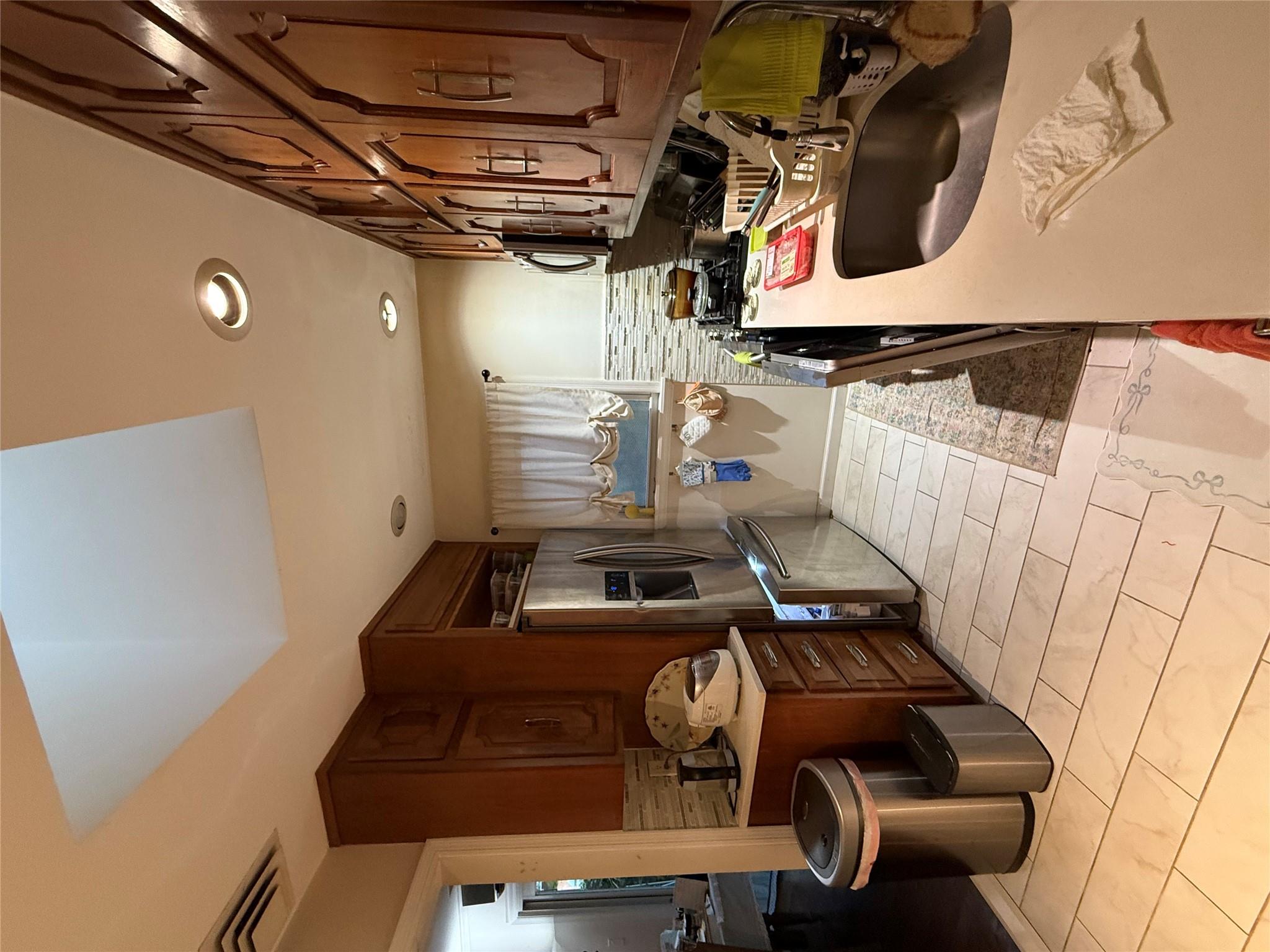 64-47 215th Street Queens, NY 11364 - Photo 4 of 15 a kitchen with a sink appliances and cabinets