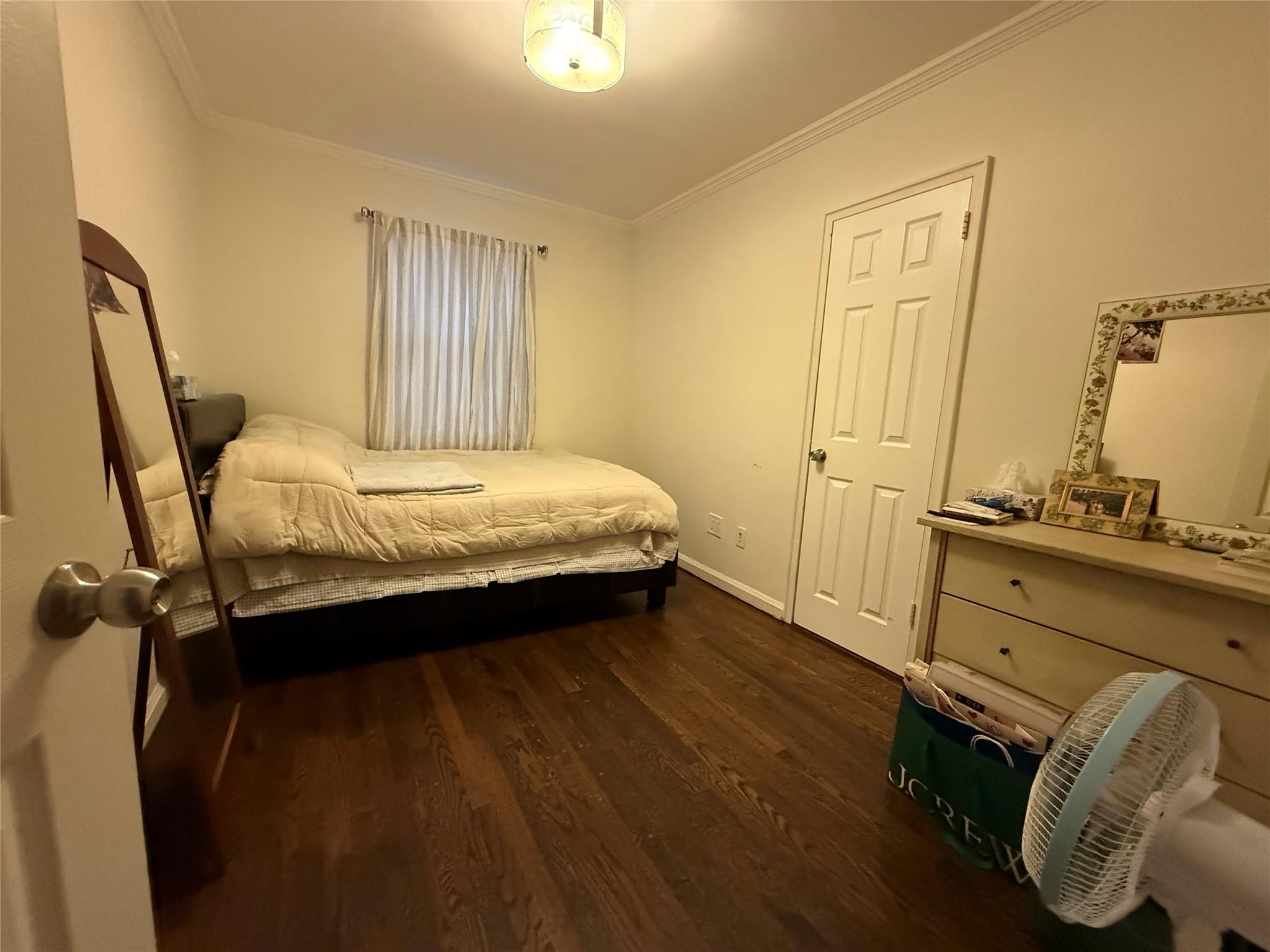 64-47 215th Street Queens, NY 11364 - Photo 8 of 15 a bedroom with a bed and wooden floor