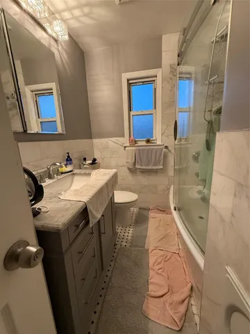 a bathroom with a sink mirror vanity and toilet